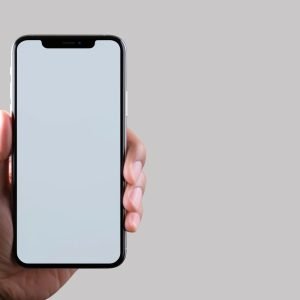 closeup hand holding blank screen smartphone grey background